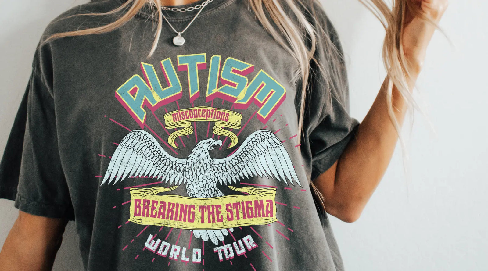 Person wearing a t-shirt with an eagle graphic and text about autism awareness.